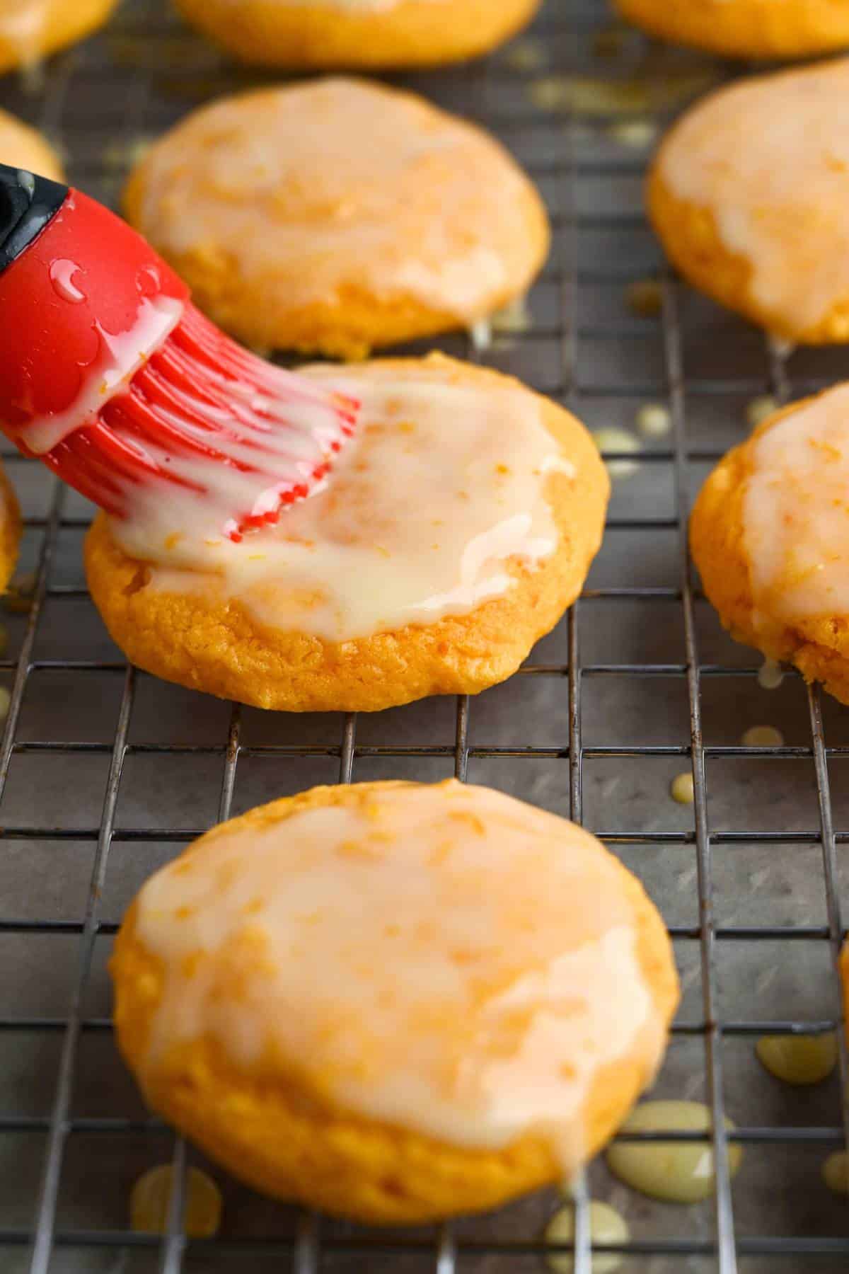 brushing a cookie with orange glaze