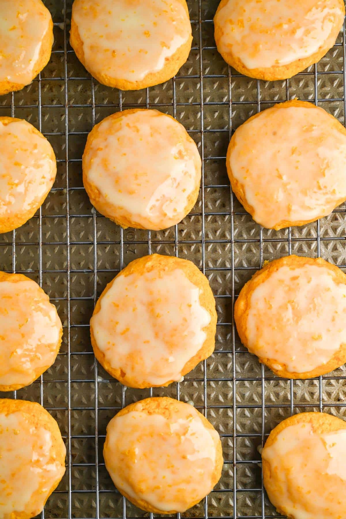 glazed orange cookies on a cookie sheet