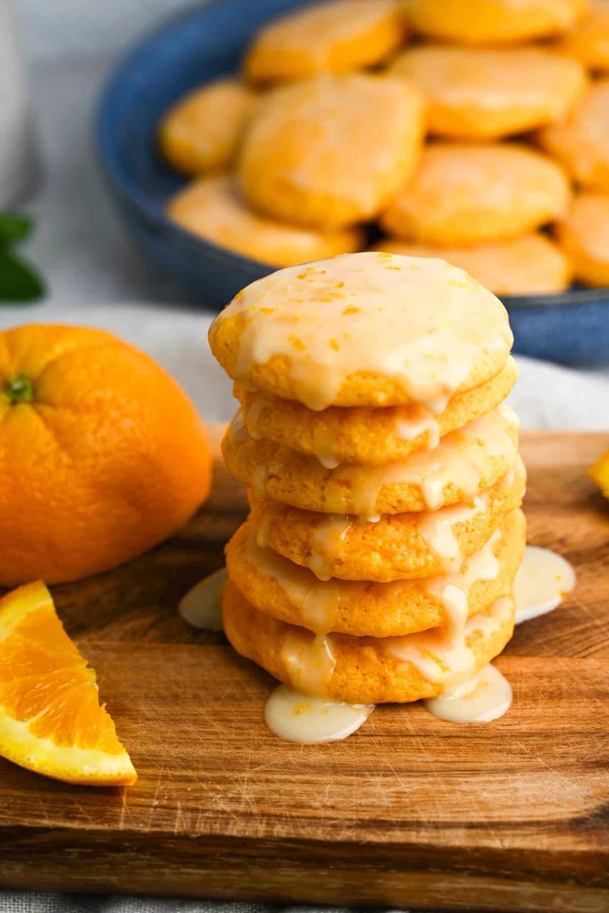 a stack of orange cookies with glaze dripping down the sides