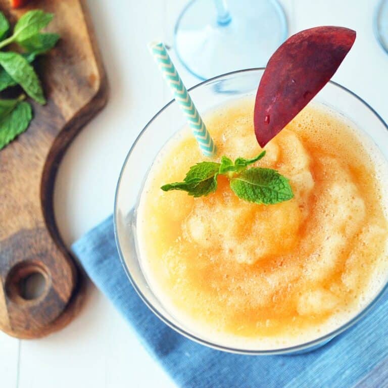 a frozen rose with peaches in a glass with mint