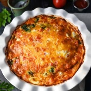 a close up photo of a baked cheeseburger quiche in a white pie dish