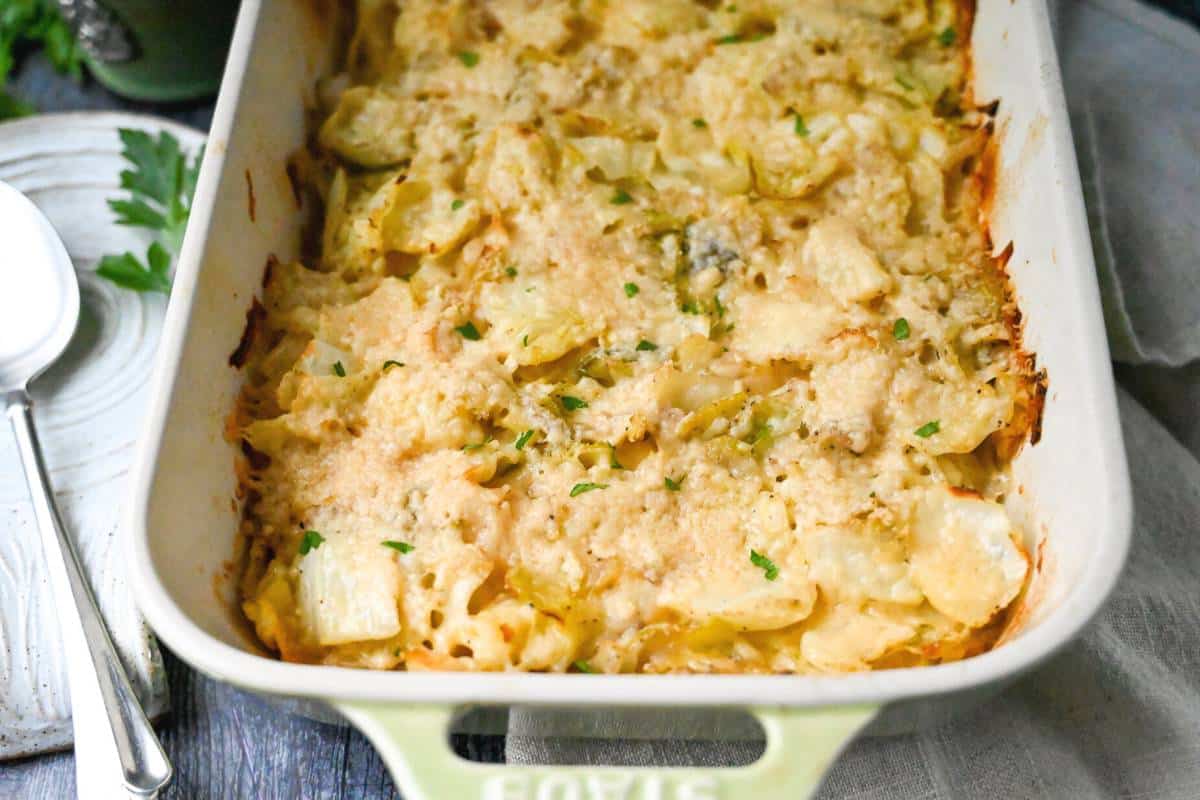 a baked casserole with cabbage and cheese with a spoon and napkin next to it