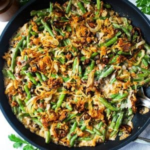 close up of a skillet loaded green bean casserole topped with homemade oven fried onions