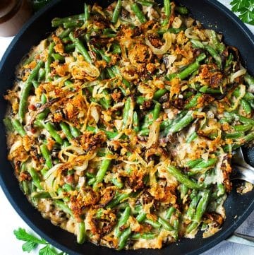 close up of a skillet loaded green bean casserole topped with homemade oven fried onions