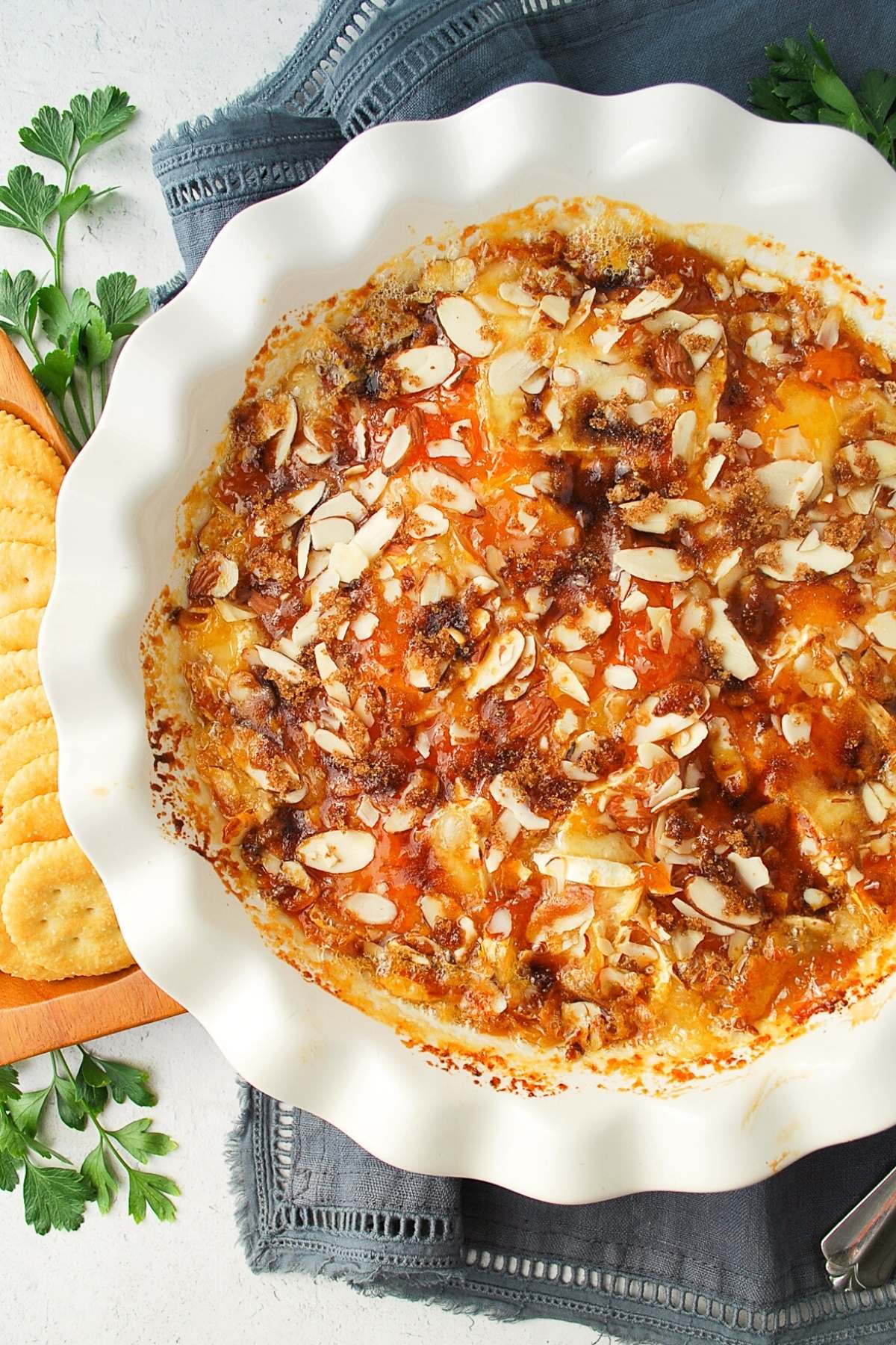 overhead photo of brown sugar baked brie in a white pie plate with crackers