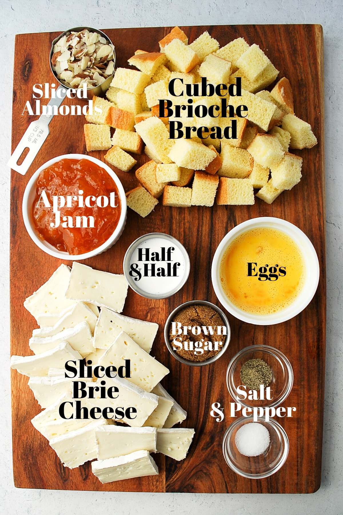 all of the ingredients for brown sugar baked brie displayed on a cutting board