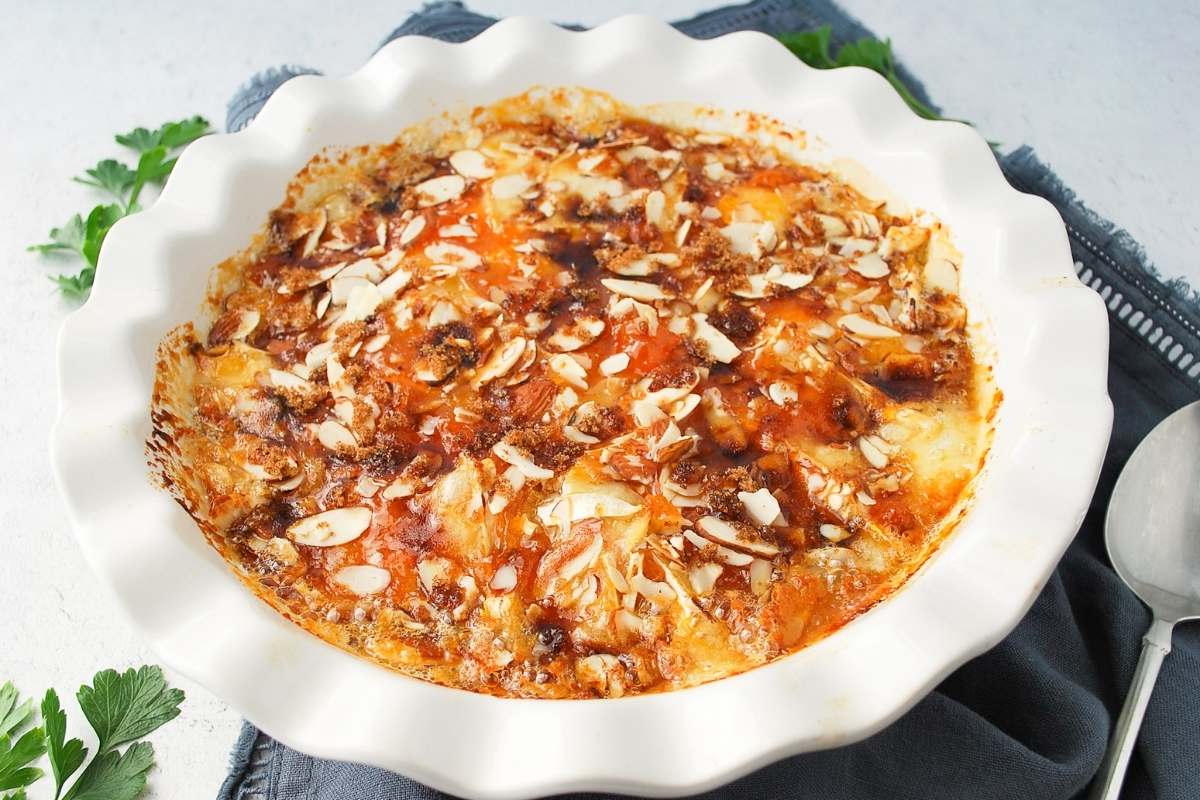 baked brie in a white pie plate with a spoon and napkin