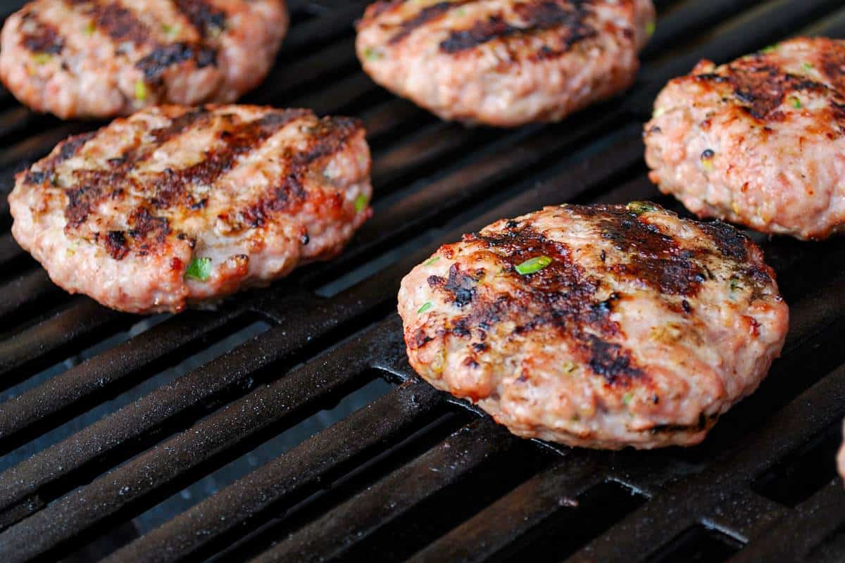 pork burgers on a grill cooking