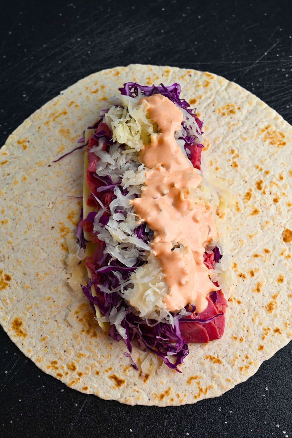 fillings on a tortilla with dressing on top