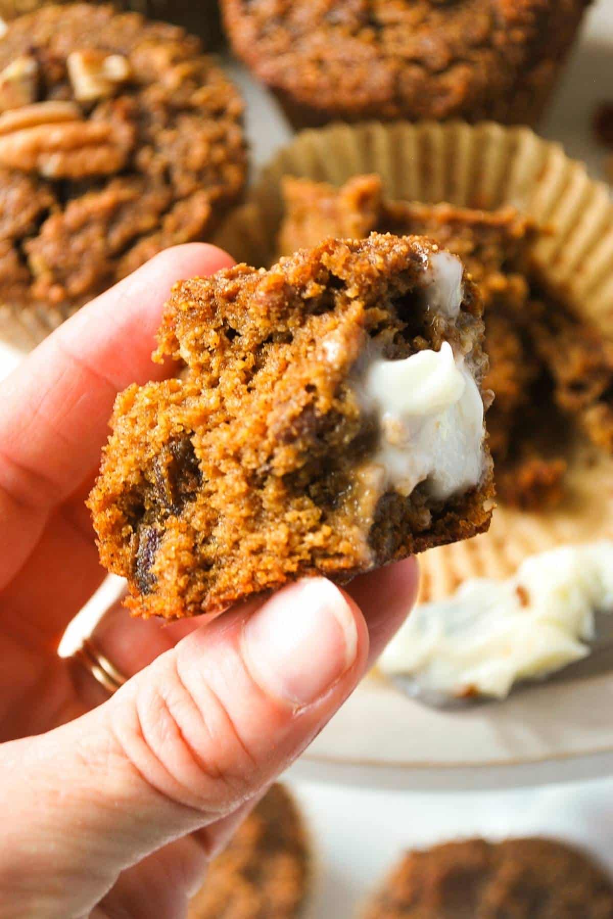 holding up a bite of almond flour pumpkin muffin with a smear of butter