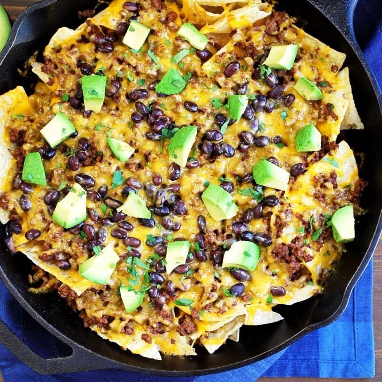 overhead photo of a skillet of nachos next to a blue napkin