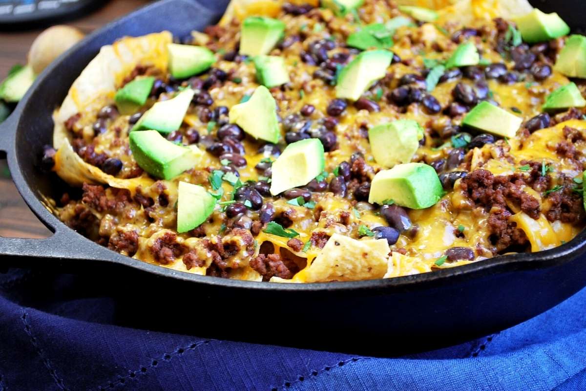 side view of a cast iron skillet of beef nachos