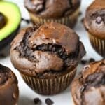 a chocolate muffin next to a sliced avocado