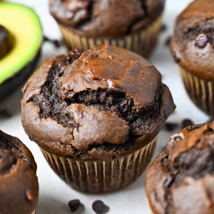 a chocolate muffin next to a sliced avocado