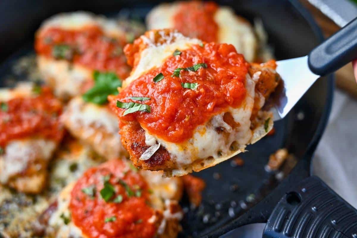 holding up a serving of chicken parm