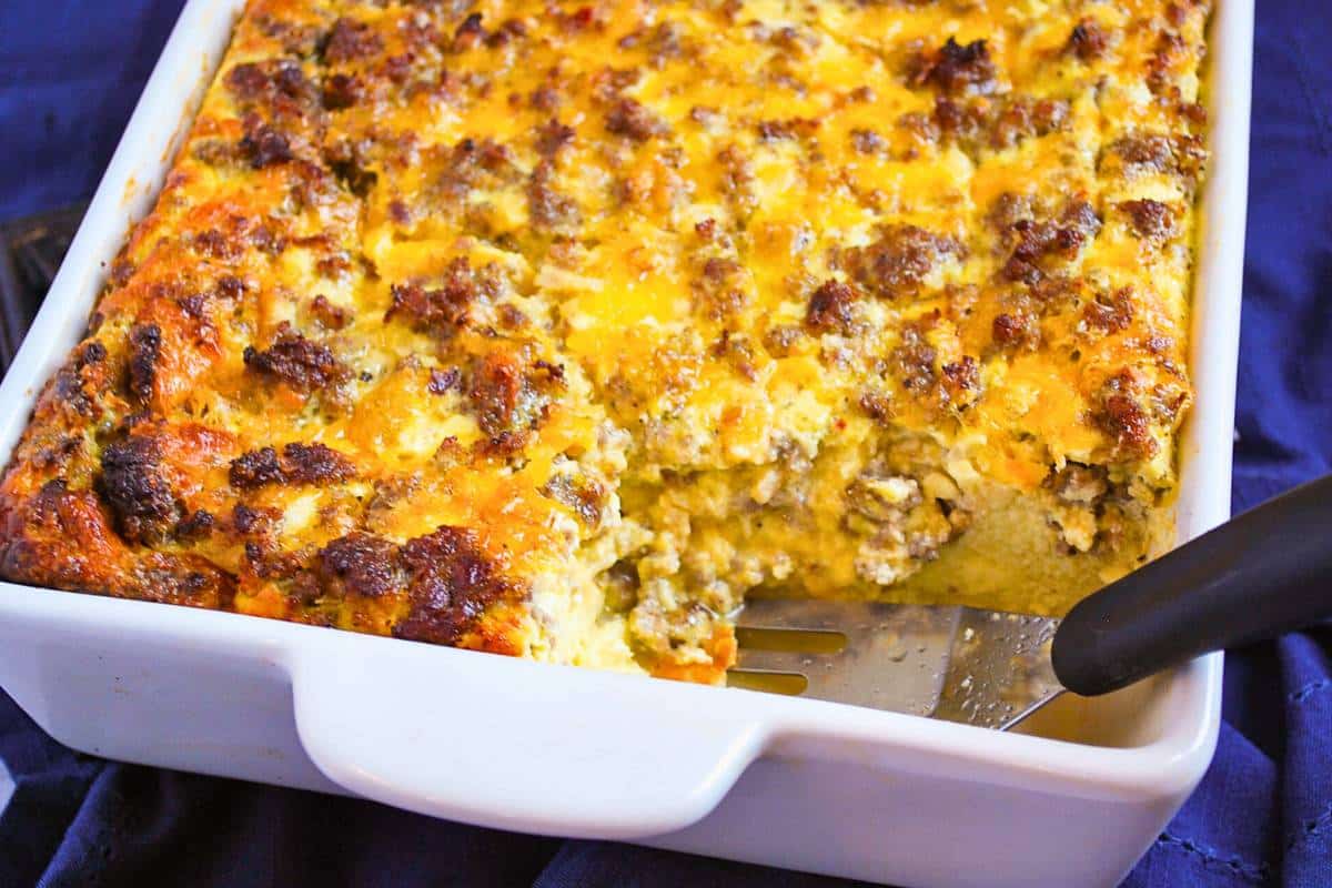 a pan of sausage egg breakfast casserole with a spatula