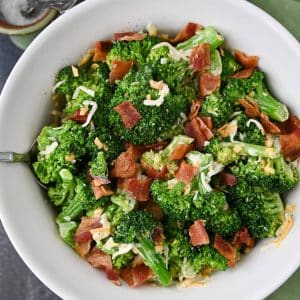 broccoli salad with bacon and cheese in a white bowl