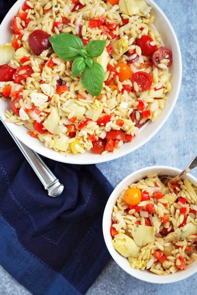two bowls of Mediterranean orzo pasta salad with fresh basil