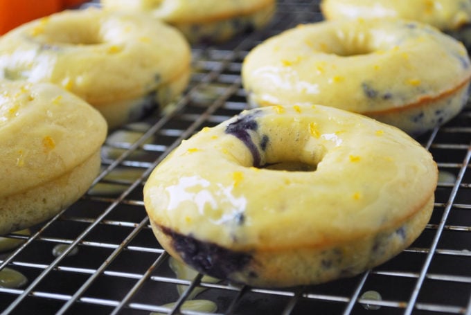 freshly baked blueberry protein donuts topped with orange glaze