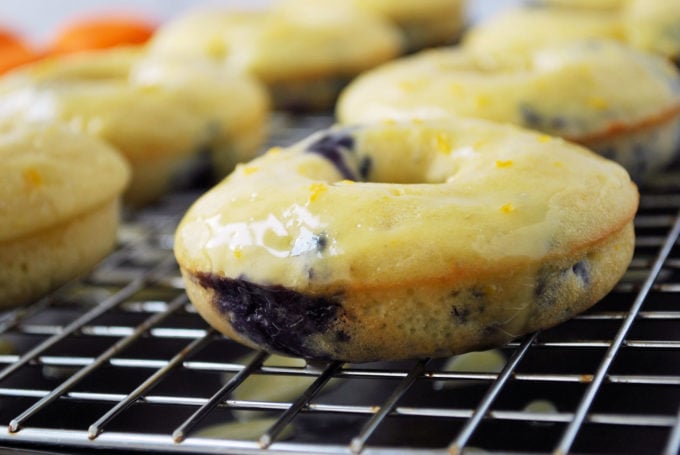 fresh blueberry protein donuts drizzled with glaze on a rack