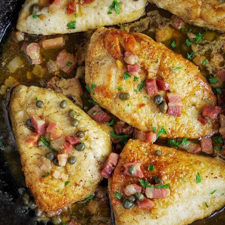 chicken breasts cooked in a skillet with pancetta, capers, and herbs