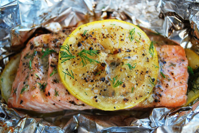 Wild salmon grilled with lemon, herbs and butter in a foil packet