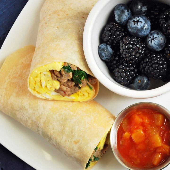 meal prep burritos on a plate with berries and salsa