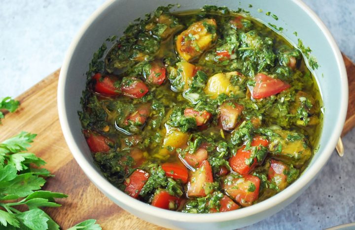 bowl of peach chimichurri sauce with parsley in the background