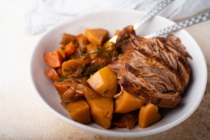 venison roast in a bowl with spoon