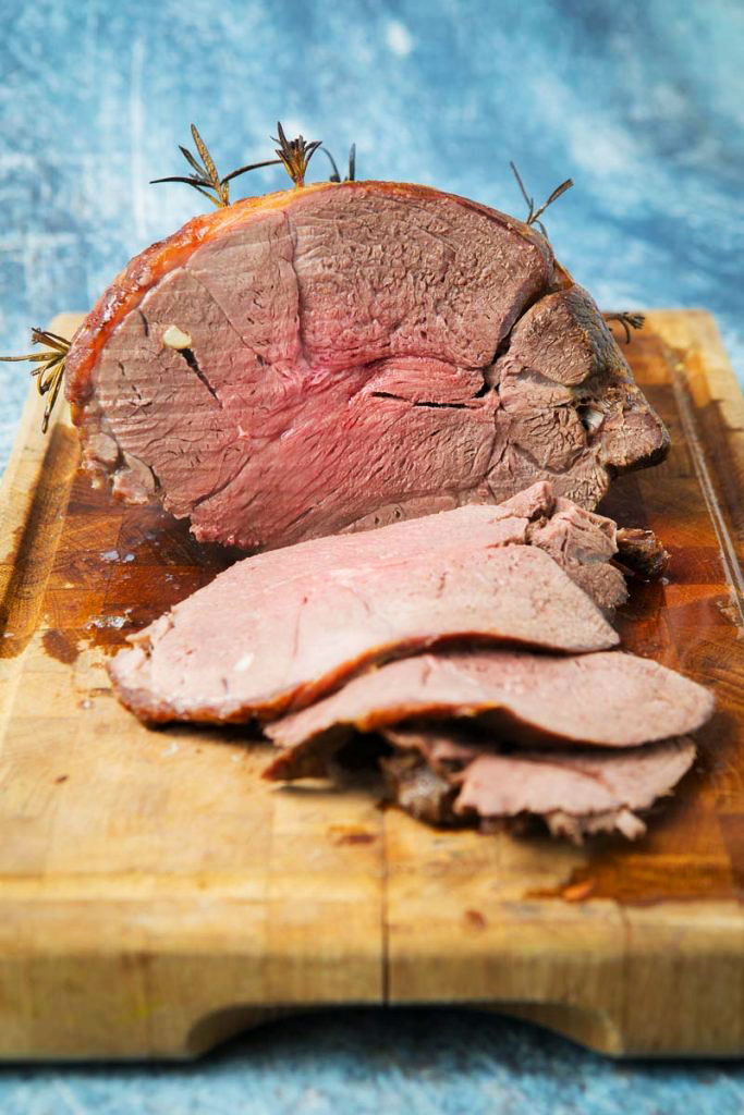 roasted venison on a cutting board sliced