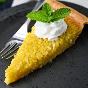 close up of a slice of summer squash pie on a plate with a fork