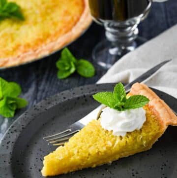 a slice of squash pie on a plate with whipped cream and mint