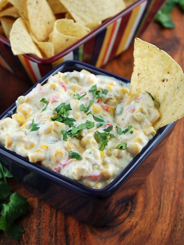 bowl of corn relish dip with chips and fresh cilantro