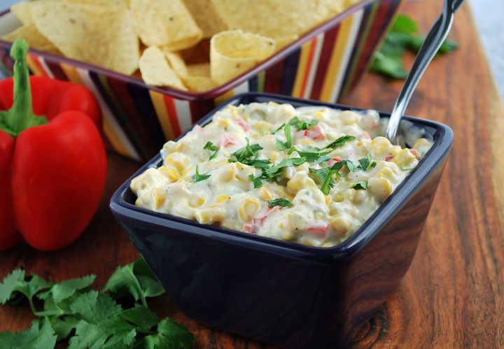 bowl of corn relish dip with a bowl of tortilla chips in the background