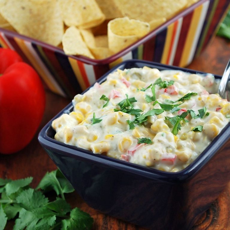 corn relish dip in a blue bowl with fresh cilantro on top