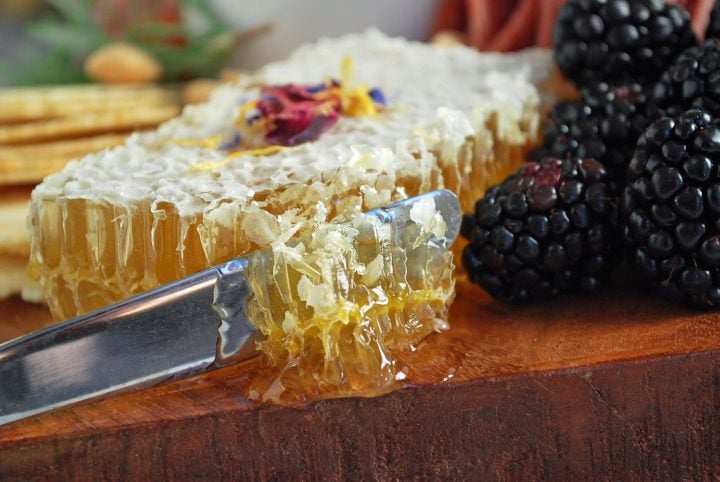 slicing into a honeycomb on a charcuterie board