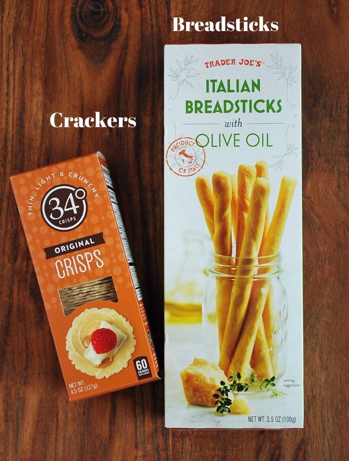 crackers and breadsticks for charcuterie on a cutting board