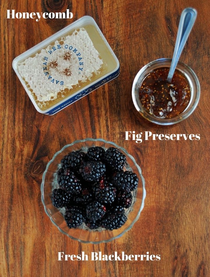 blackberries, fig preserves, and honeycomb for charcuterie on a cutting board