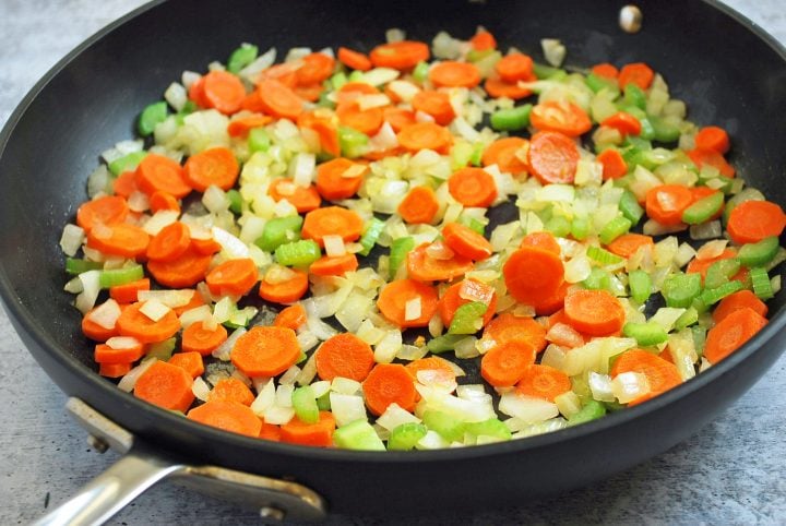 carrots, onions, and celery cooking in a skillet