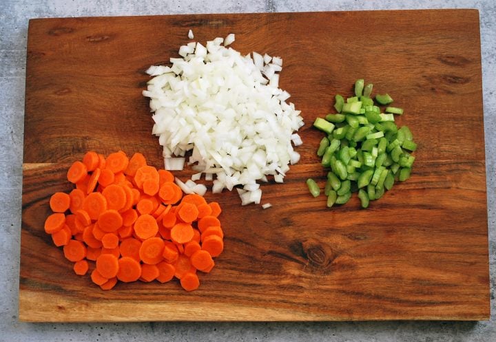 chopped carrots, onions, and celery on a cutting board