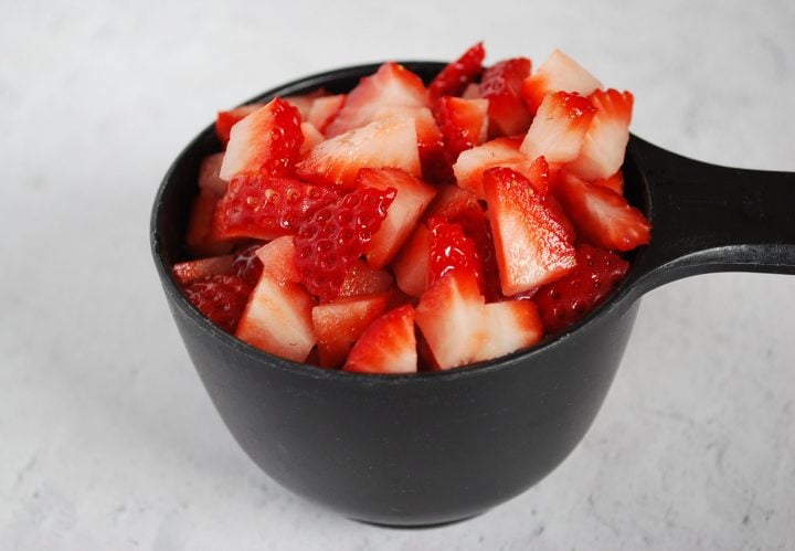 chopped fresh strawberries in a measuring cup