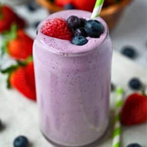 close up of a smoothie in a glass with a straw