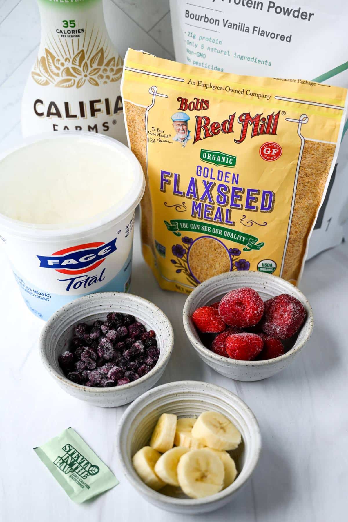 ingredients to make a frozen berry smoothie on a counter