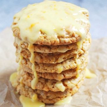 tall stack of orange cookies dripping with orange glaze