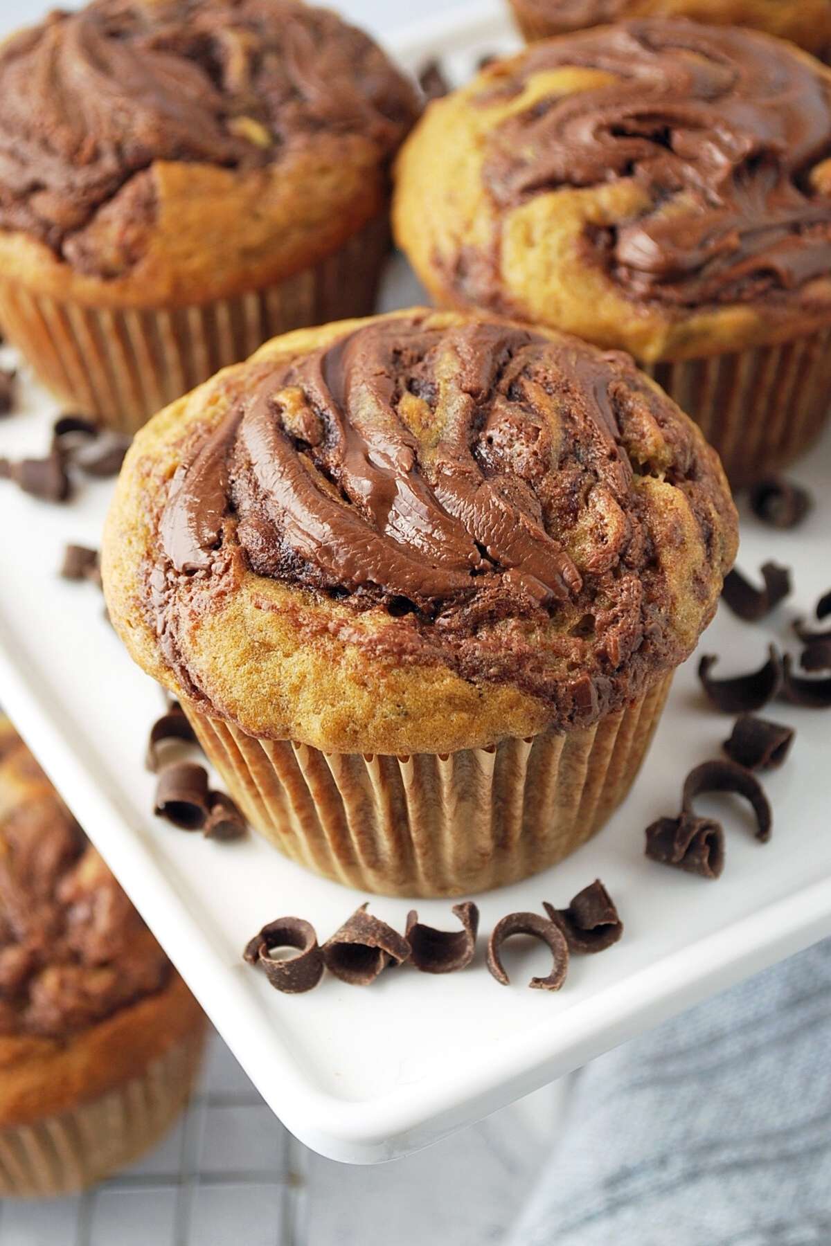 close up of a banana nutella muffin on a platter with shaved chocolate