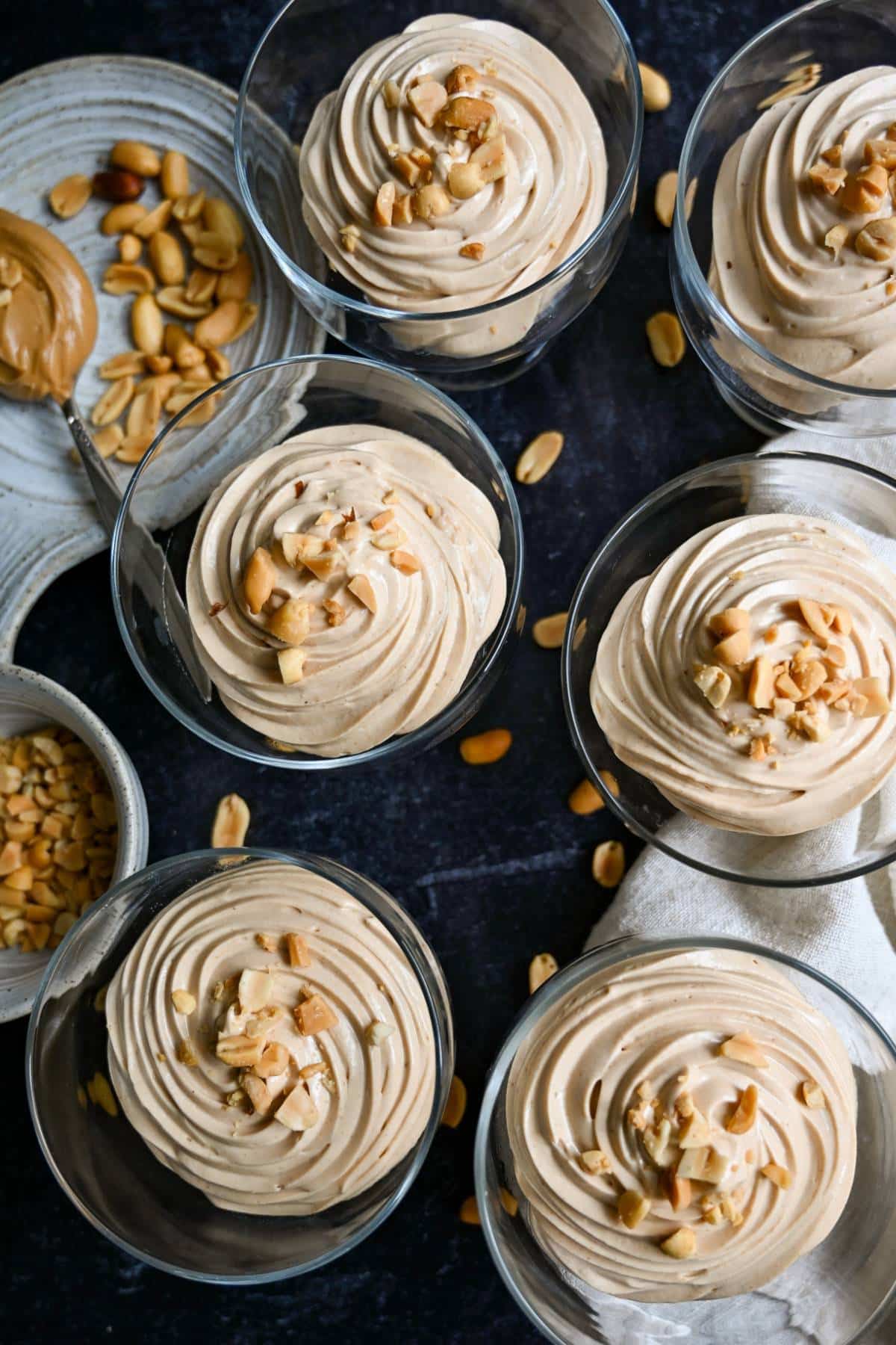 peanut butter greek yogurt mousse in six dessert glasses with peanuts