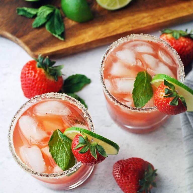 overhead photo of two strawberry mojitos with sugar rim, fresh mint and lime