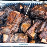 smoked beef short ribs in a pan on the grill