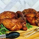 two smoked chickens on a cutting board