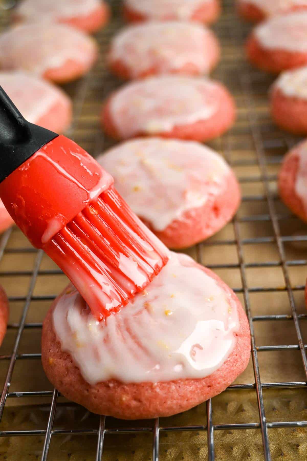 glazing strawberry cookies with a pastry brush